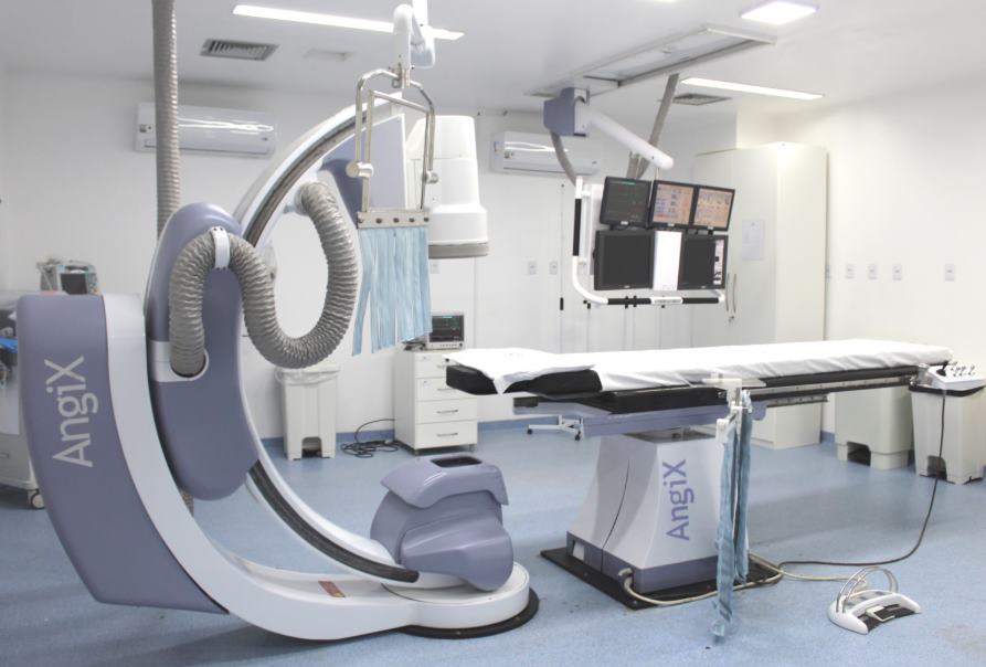 Arco de angiografia posicionado sobre a mesa de procedimento